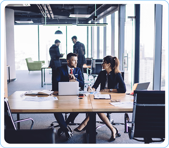 Two Business Professionals Discussing Salesforce Migration Strategies in a Modern Office Environment